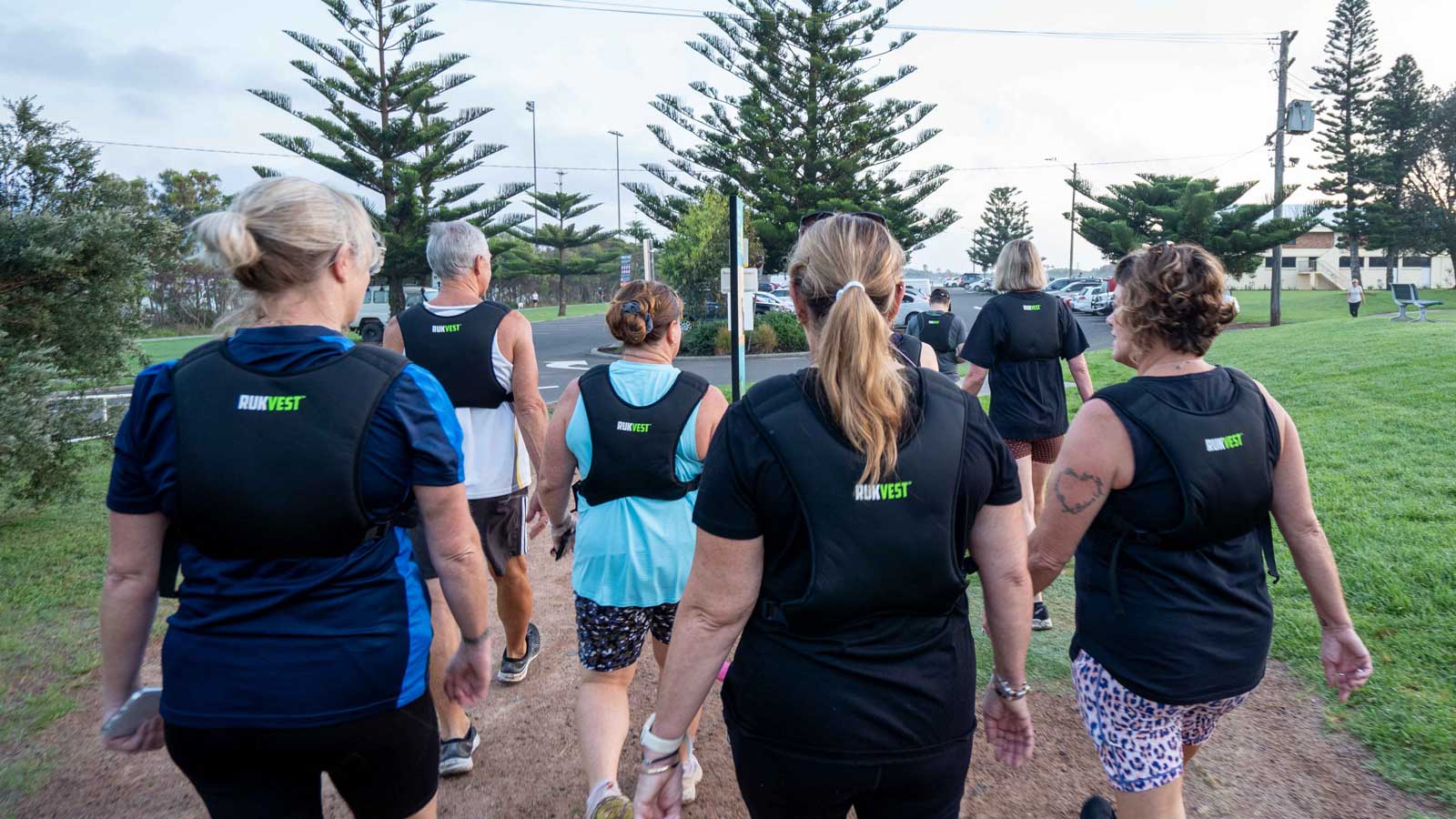 Group of perimenopausal women walking outdoors wearing RUKVEST weighted vests