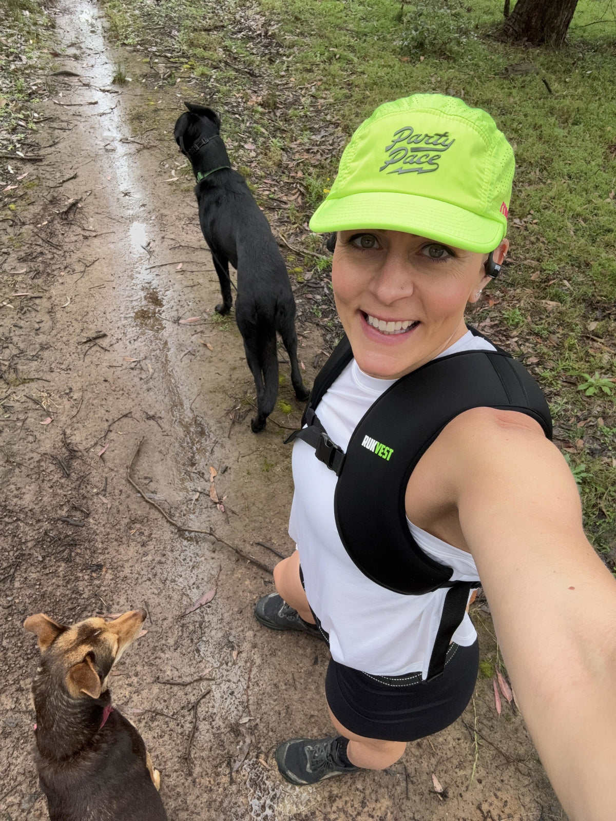Smiling woman in a cap on a walk with her dog, wearing a RUKVEST